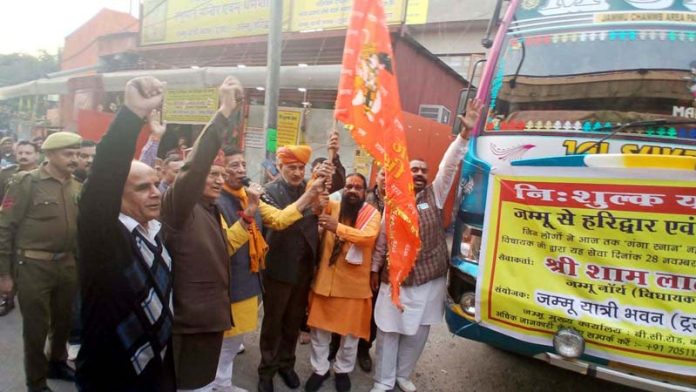 MLA Sham Sharma and Pawan Shastri flagging off bus to Haridwar from Jammu on Friday.