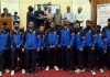 Dignitaries presenting trophy to winning team while posing for group photograph.