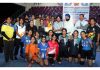 Dignitaries posing along with winning team members and trophy.
