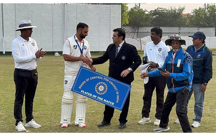 Player receiving man of the match award from dignitaries during a match at Jammu.