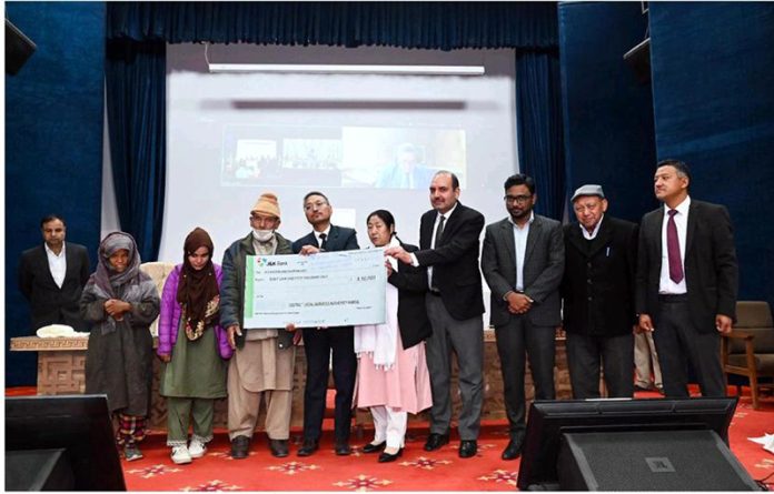 Justice Sanjeev Kumar, the Executive Chairman, LLSA presenting a cheque of compensation during a function in Kargil on Saturday. Justice Sanjeev Kumar, the Executive Chairman, LLSA presenting a cheque of compensation during a function in Kargil on Saturday.