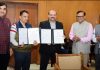 SMVDU Registrar and TSL Chief Sales Manager displaying copies of MoU signed by them.