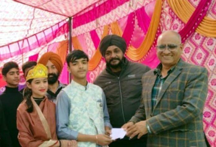 A police officer awarding students with the cash prize on conclusion of a Nukkad Natak in Kathua on Wednesday.