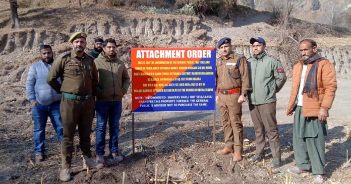Police and district Rajouri administration officials seizing a terrorist's property in Kotranka on Friday.