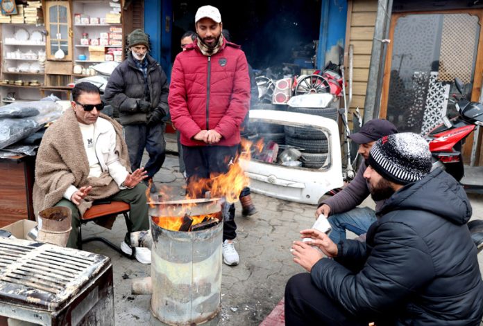 People warm themselves on a roadside in Srinagar on Wednesday. -Excelsior/Shakeel People warm themselves on a roadside in Srinagar on Wednesday. -Excelsior/Shakeel