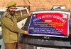 A police official pasting attachment notice on a vehicle allegedly used in drug trafficking in Handwara on Tuesday.
