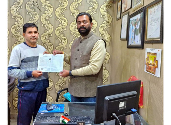 Chairman Samvedna Society, Keshav Chopra gives Ration Card to a commoner in Jammu on Monday.