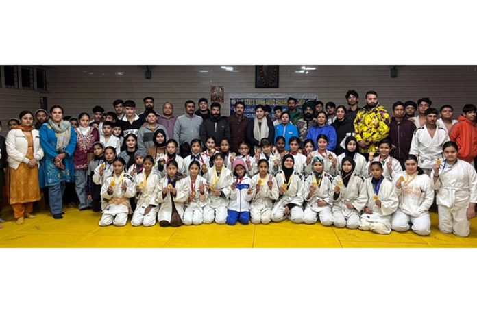 Players along with organisers and others pose for a group photograph at the start of JK Judo Championship in Jammu on Friday.