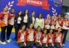J&K Girls Gymnastics team posing along with coaching staff.
