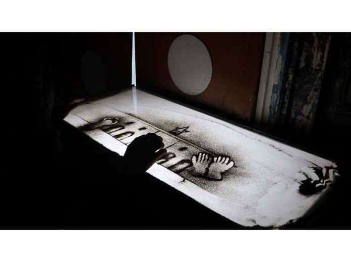 Sand artist Sahil Manzoor working on an art piece in his work-station at old city Srinagar. -Excelsior/Mohsin Nisar