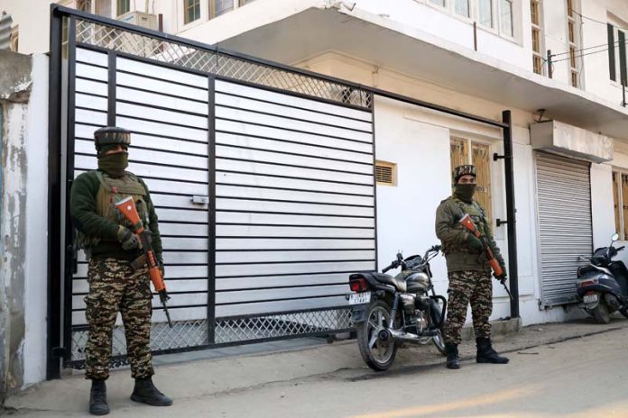 Security personnel stand guard during NIA raids in Srinagar on Tuesday. -Excelsior/Shakeel Security personnel stand guard during NIA raids in Srinagar on Tuesday. -Excelsior/Shakeel