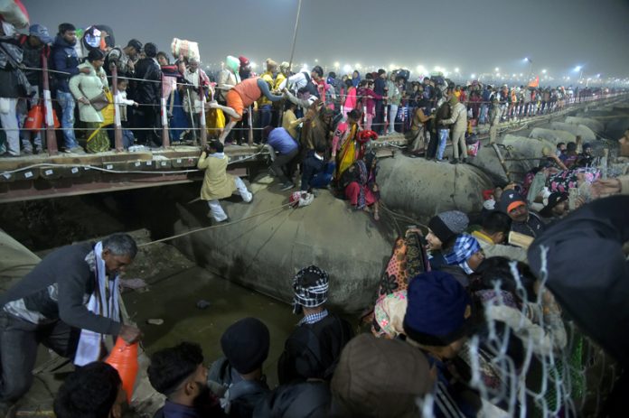 People gather on a footbridge after a stampede in Prayagraj on Wednesday. (UNI)