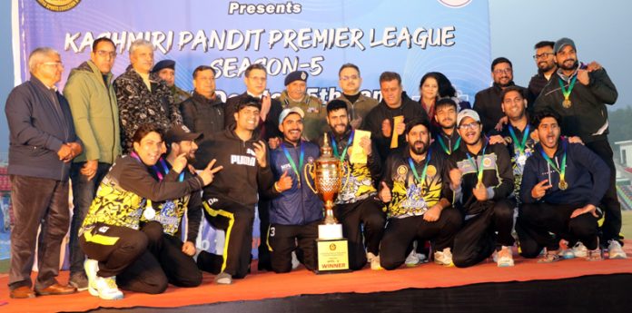 Winning team posing along with dignitaries and trophy.