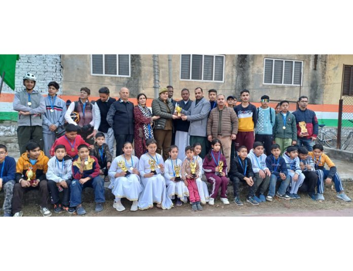 Young cyclists posing along with trophies and dignitaries during an event at Udhampur on Sunday.