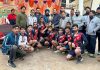 Handball players posing along with trophy at Poonch.