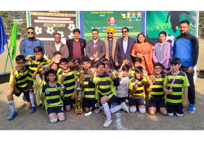 Winning team posing along with trophy.