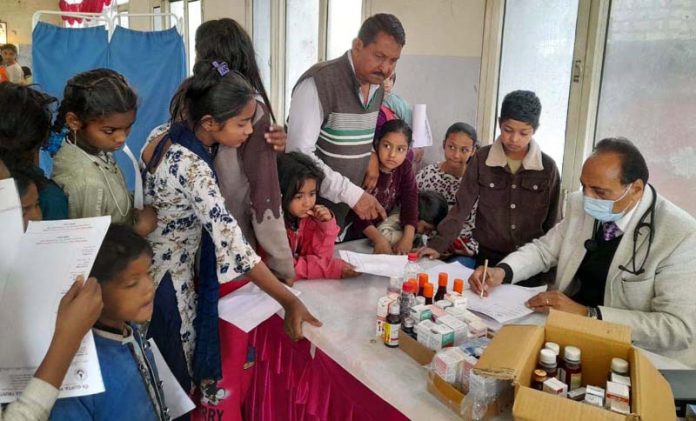 Doctor prescribing medicine to a patient during the medical camp at Rajeev Nagar, Jammu.