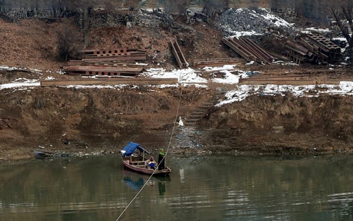 Parveena (name changed) rowing boat in River Jhelum to ferry passengers for cross over. —Excelsior/Mohsin Nisar 