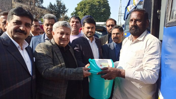 Transport Commissioner Vishesh Paul Mahajan presenting a dustbin to a bus driver at Transport Yard, Narwal in Jammu.