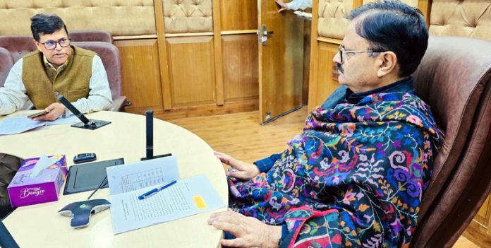 Minister Javed Rana being briefed by an officer.