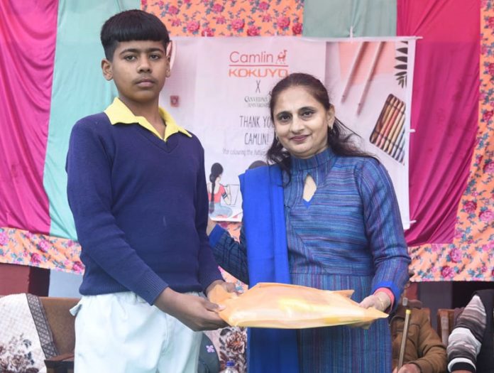 Ashi Chauhan, Director of Sanvedna Aur Samvardhan Foundation presenting stationery to a student at Samba.