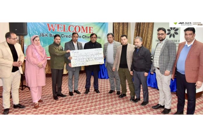 Dignitaries from J&K Bank presenting cheque to a family member of the deceased borrower in Srinagar on Wednesday.