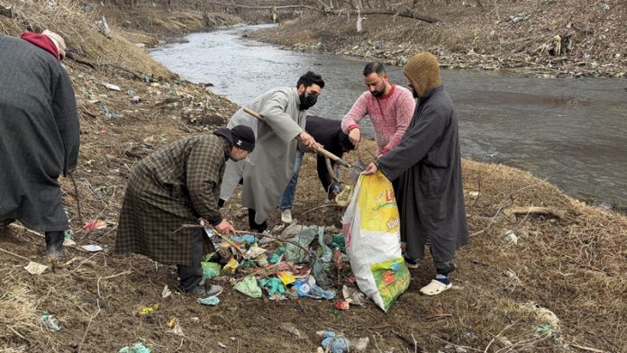 Residents cleaning stream in Anantnag. - Excelsior/Sajad Dar