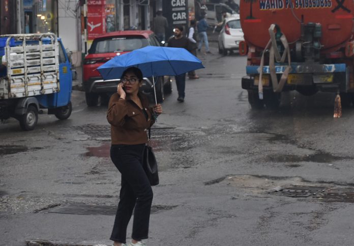 Amidst rain, a girl covering her with umbrella, moving through a road in Jammu on Thursday. — Excelsior/Rakesh Amidst rain, a girl covering her with umbrella, moving through a road in Jammu on Thursday. — Excelsior/Rakesh