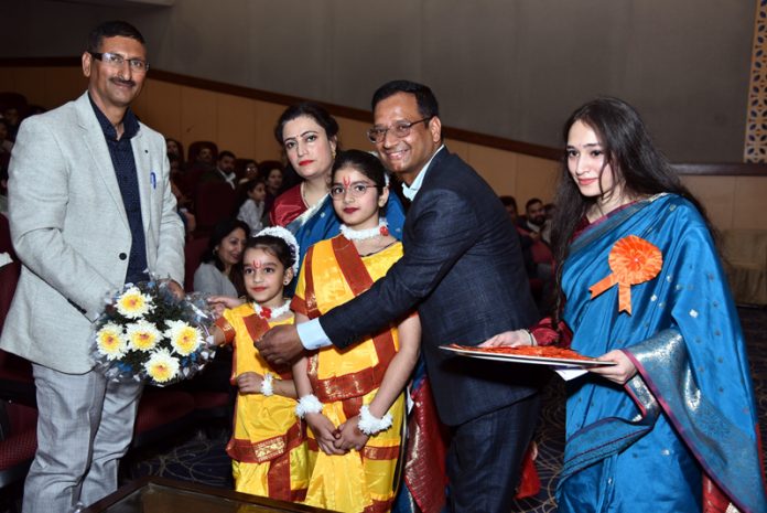 Students and school management presenting a bouquet to dignitary during 15th Annual Day celebration at JK Convent School.