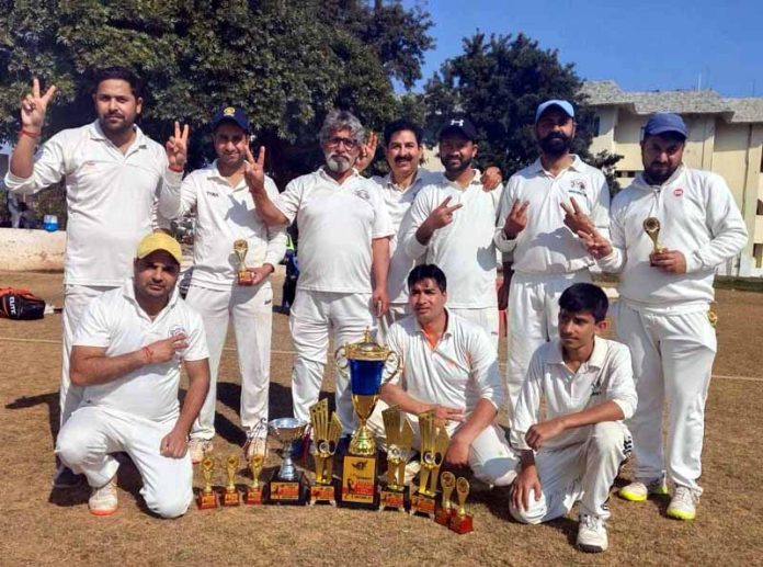 Winning team posing for a group photograph with trophies.