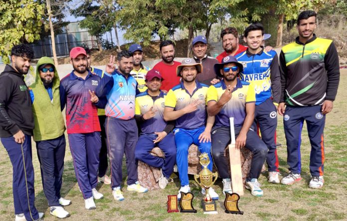 Winning team posing along with trophy.