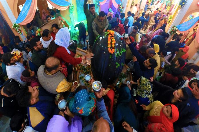 Devotees offering milk and other items on Shivlingam in Ranbireshwar Temple near Shalimar Chowk Jammu. -Excelsior/Rakesh