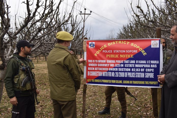Police installing banner of property attachment. —Excelsior/Aabid Nabi Police installing banner of property attachment. —Excelsior/Aabid Nabi
