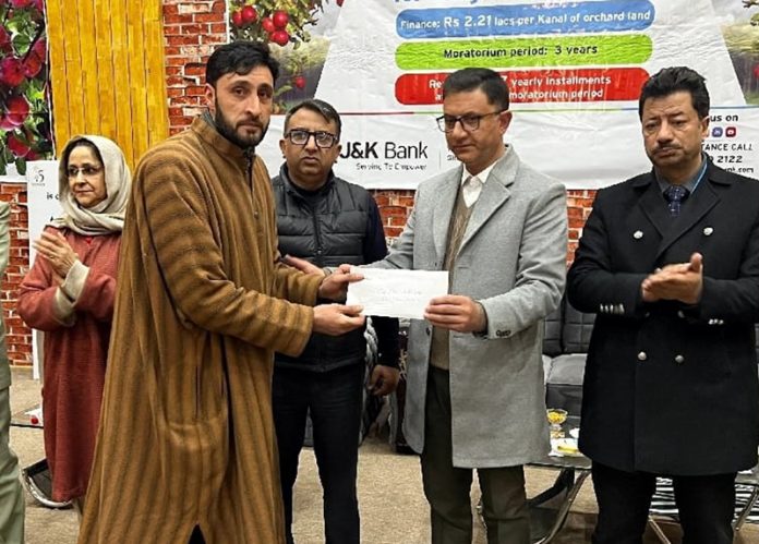 A senior officer handing over sanction letter of high density plantion loan to a farmer during camp at Pulwama.