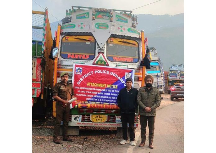 Cops standing in front of the attached truck of drug peddler.
