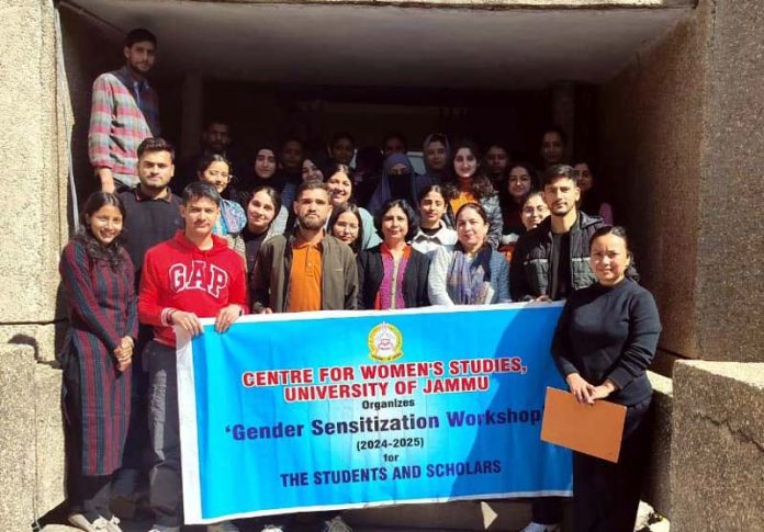 Participants displaying banner of gender sensitisation workshop.