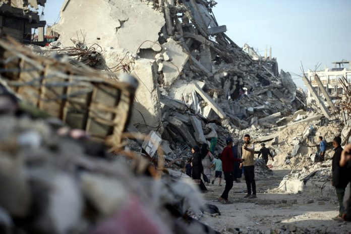 Palestinians walk among destroyed buildings in Jabalia in northern Gaza Strip. (UNI)
