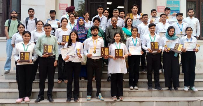 Students posing along with mementos and certificates.