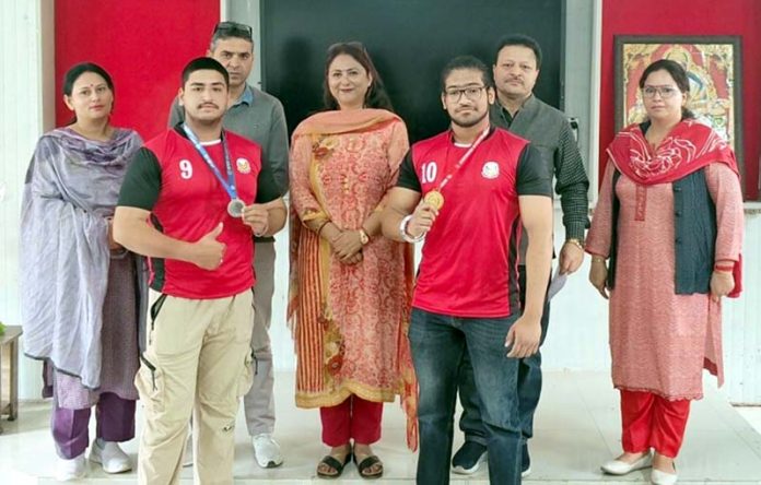 Dignitaries with students of GDC Kunjwani, who display medals they won in Power Lifting.