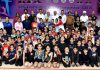 Players from various districts posing with trophy alongside dignitaries during J&K Gymnastics Championships at MA Stadium, Jammu.