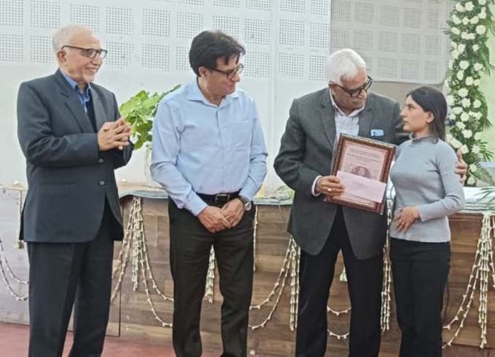 Vijay Bakaya presenting scholarship to a girl student during a function by Aash Foundation.