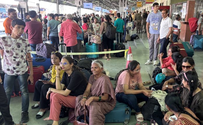 Stranded tourists waiting for train to board at Jammu Railway Station. -Excelsior/Rakesh