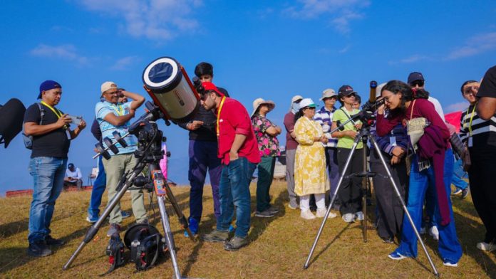 People in queues behind telescopes, pointing skyward and constellations capturing dark sky moments in Uttarakhand.