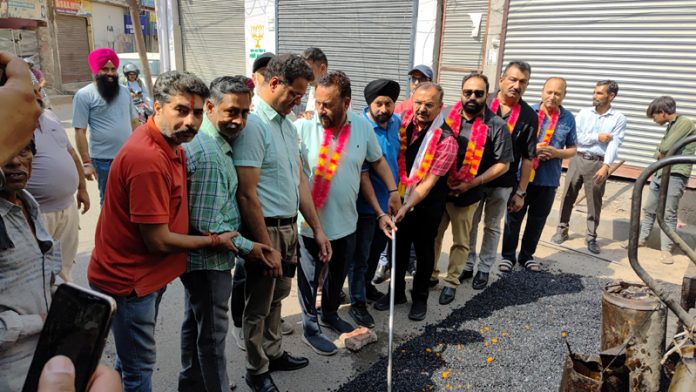 MLA Bahu, Ch Vikram Randhawa kick starting blacktopping of road in Nanak Nagar on Tuesday.