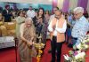 Dignitary lighting traditional lamp during 20th Foundation Day celebration at Heritage School.