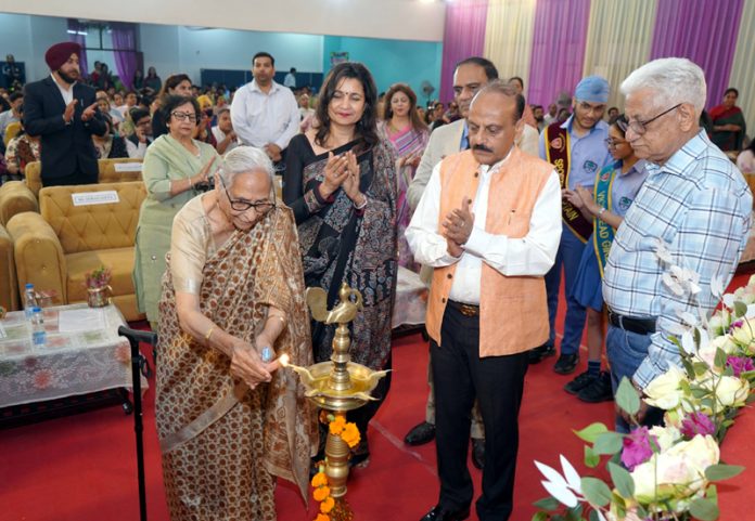 Dignitary lighting traditional lamp during 20th Foundation Day celebration at Heritage School.