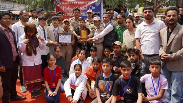 SSP Doda, Sandeep Mehta giving mementoes to the students who participated in play to aware public about addiction. -Excelsior/ Tilak Raj SSP Doda, Sandeep Mehta giving mementoes to the students who participated in play to aware public about addiction. -Excelsior/ Tilak Raj