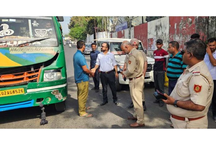 A team of RTO Jammu inspecting a mini-bus for overloading near Bikram Chowk, Jammu.