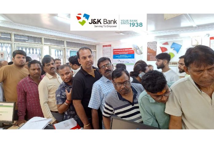 People waiting for their turn in a queue to register for Amarnath Yatra at a branch of J&K Bank in Jammu.