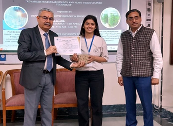 Professor (Dr) Jata Shankar and Professor (Dr) Hemant Sood felicitating a student during a workshop on Tuesday.